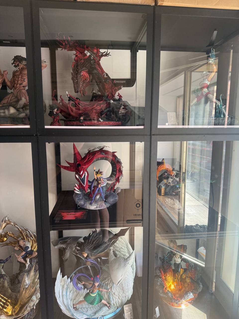 Multiple vitrines with Attack Titan, Red-Eyes, Gajeel Wendy and fire statue