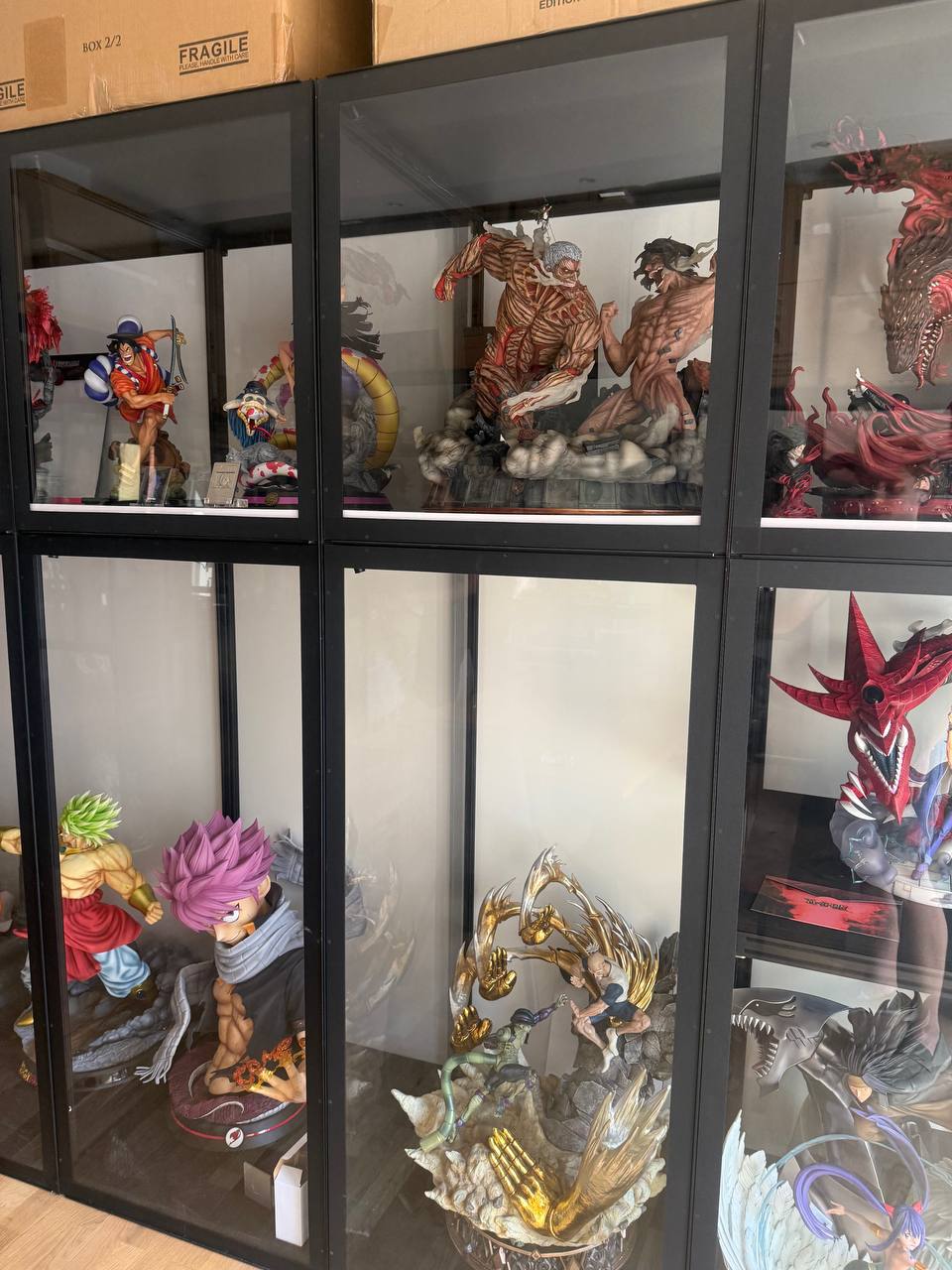 Three display vitrines with One Piece, Attack on Titan and Hunter x Hunter
